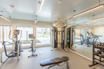 A spacious gym with a variety of equipment including treadmills, stationary bikes, and weight machines.at Rowat Lofts, Des Moines, IA 50309  